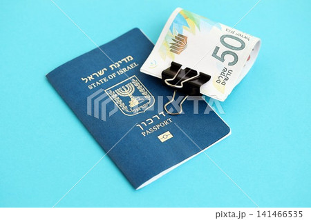 Israel New Shekels banknotes and passport on blue background. The current Israel money bills 141466535