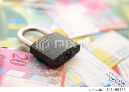 Swiss franc banknotes and padlock. The current francs money bills with lock lies in big amount Swiss franc banknotes and padlock. The current francs money bills with lock lies in big amount 141466553