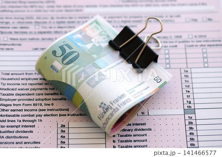 Swiss franc banknotes and tax form. The current francs money bills lies on tax return form 141466577