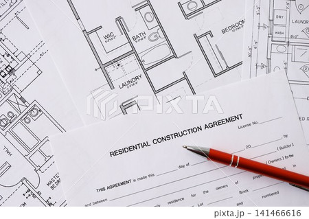 Pen on residential construction agreement and planning blueprints of residential building project Pen on residential construction agreement and planning blueprints of residential building project 141466616