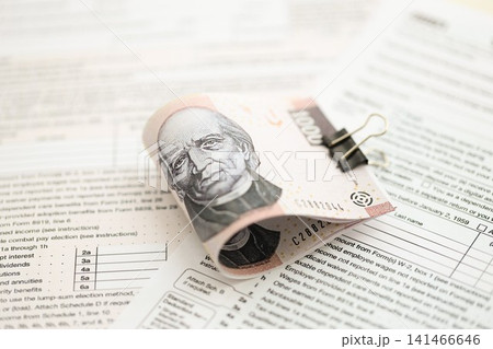 Mexican pesos money bills in big amount lies on table with tax forms close up Mexican pesos money bills in big amount lies on table with tax forms close up 141466646