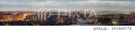 Panorama of night aerial view of Ivano-Frankivsk city, Ukraine. Scene of modern night city with bright lights of tall buildings. Residential quaters and construction cranes in modern urban space. Panorama of night aerial view of Ivano-Frankivsk city, Ukraine. Scene of modern night city with bright lights of tall buildings. Residential quaters and construction cranes in modern urban space. 141466778