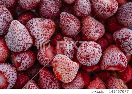 Frozen strawberries close up background with ice crystals and natural texture Frozen strawberries close up background with ice crystals and natural texture 141467077