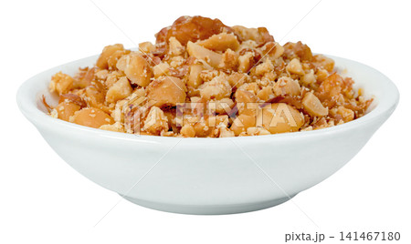 White ceramic bowl filled with crushed roasted peanuts isolated. Close-up of crunchy nut pieces, perfect for food topping or snack ingredient. High-quality studio shot. 141467180