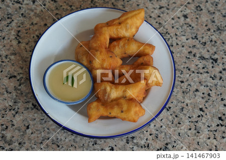 top view hot four pieces of patongko and condensed milk in a ceramic cup, placed on a white and blue enamel plate on a marble surface background, food, dessert, copy space top view hot four pieces of patongko and condensed milk in a ceramic cup, placed on a white and blue enamel plate on a marble surface background, food, dessert, copy space 141467903