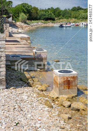 Concrete pier and pebble beach. Adriatic coast, Istria, Croatia. Concrete pier and pebble beach. Adriatic coast, Istria, Croatia. 141468177
