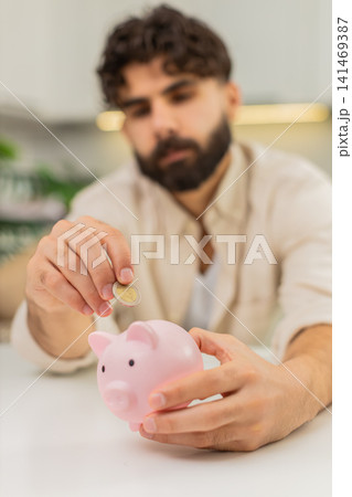 Indian man holding small piggy bank coin saving money dream about future personal savings big budget 141469387