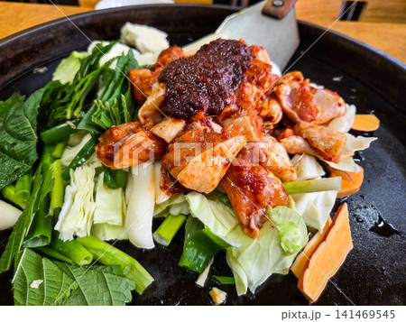 Spicy Korean Chicken Stir Fry Dakgalbi with Vegetables on Iron Pan Spicy Korean Chicken Stir Fry Dakgalbi with Vegetables on Iron Pan 141469545
