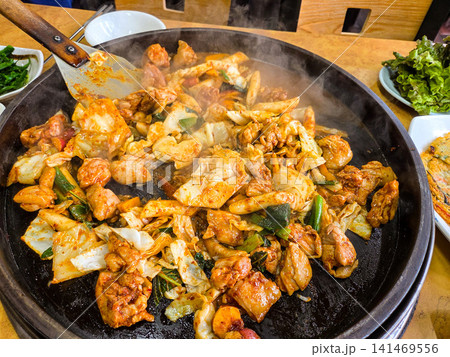 Spicy Korean Chicken Stir Fry Dakgalbi with Vegetables on Iron Pan Spicy Korean Chicken Stir Fry Dakgalbi with Vegetables on Iron Pan 141469556