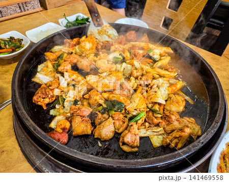 Spicy Korean Chicken Stir Fry Dakgalbi with Vegetables on Iron Pan Spicy Korean Chicken Stir Fry Dakgalbi with Vegetables on Iron Pan 141469558