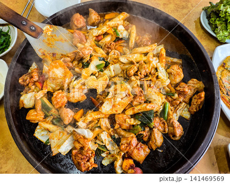 Spicy Korean Chicken Stir Fry Dakgalbi with Vegetables on Iron Pan Spicy Korean Chicken Stir Fry Dakgalbi with Vegetables on Iron Pan 141469569