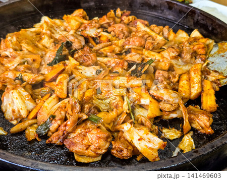 Spicy Korean Chicken Stir Fry Dakgalbi with Vegetables on Iron Pan Spicy Korean Chicken Stir Fry Dakgalbi with Vegetables on Iron Pan 141469603