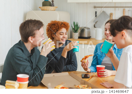 Home party. Friends spending time together having fun laughing communicating at home. Happy diverse group eating pizza drinking beer or lemonade. Mixed race young buddies best friends enjoying weekend Home party. Friends spending time together having fun laughing communicating at home. Happy diverse group eating pizza drinking beer or lemonade. Mixed race young buddies best friends enjoying weekend 141469647
