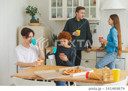 Home party. Friends spending time together having fun laughing communicating at home. Happy diverse group eating pizza drinking beer or lemonade. Mixed race young buddies best friends enjoying weekend Home party. Friends spending time together having fun laughing communicating at home. Happy diverse group eating pizza drinking beer or lemonade. Mixed race young buddies best friends enjoying weekend 141469674