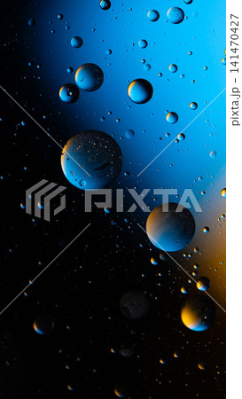 Oil and water droplets mixing on a colorful background creating an abstract texture Oil and water droplets mixing on a colorful background creating an abstract texture 141470427