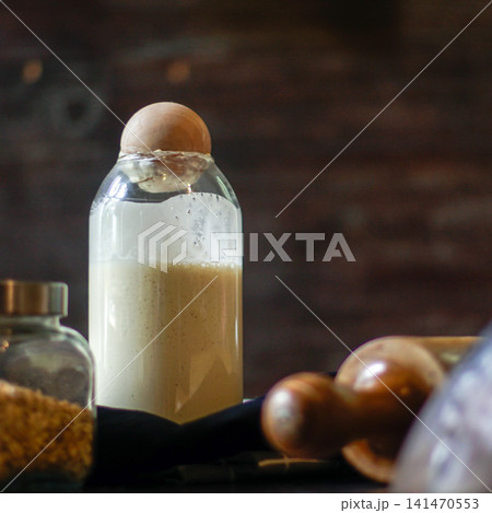 Close-up of Active Sourdough Starter with Natural Fermentation Bubbles in Glass Jar for Artisan Homemade Bread Baking 141470553