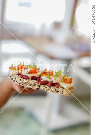 Healthy Open-Faced Chicken Sandwich with Soft-Boiled Egg, Kidney Beans and Cherry Tomatoes on Seeded Artisan Bread 141470559