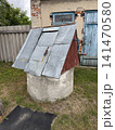 Rustic Old Well with Weathered Farm Building 141470580