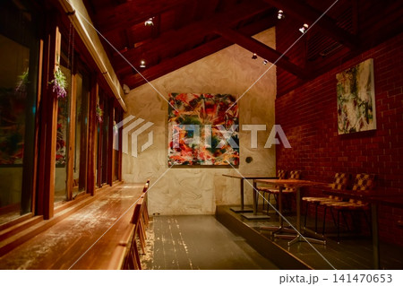 木目と赤レンガ調がおしゃれな落ち着いたカフェ・レストランの内観と壁面アート 141470653