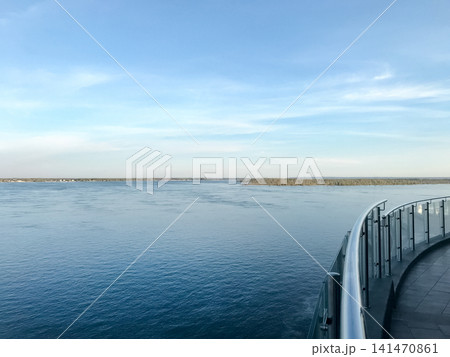 A serene horizon featuring a calm river and a distant shore under a blue sky. The Volga River. 141470861