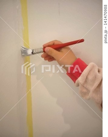 Neat painting of a wall corner with a flat brush along painter's tape. Neat painting of a wall corner with a flat brush along painter's tape. 141470988