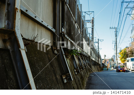 青空の下、日本の都市風景に広がるコンクリート壁と電線 青空の下、日本の都市風景に広がるコンクリート壁と電線 141471410