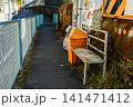 青いフェンスと寂れたベンチ、自動販売機がある日本の歩道 141471412