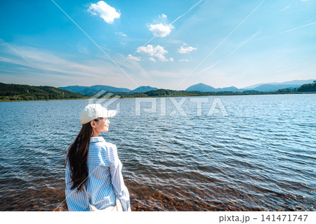 湖の水辺に立ち遠くを見る白ワンピースの女性 湖の水辺に立ち遠くを見る白ワンピースの女性 141471747