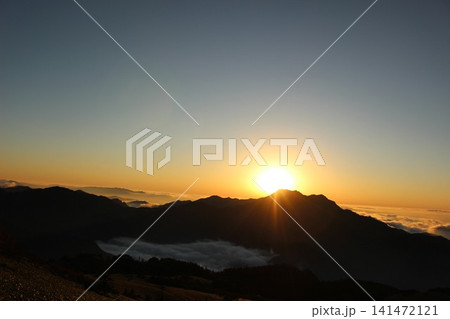 愛媛県・石鎚山系瓶ヶ森から見る幻想的な夕暮れ マジックアワーの雲海と夕日に映える石鎚山の山影 愛媛県・石鎚山系瓶ヶ森から見る幻想的な夕暮れ マジックアワーの雲海と夕日に映える石鎚山の山影 141472121