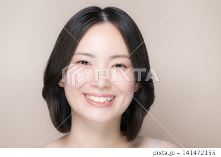 ピンクベージュ背景美しい日本人女性 美しい肌とナチュラルメイクの美容カメラ目線笑顔クローズアップ ピンクベージュ背景美しい日本人女性 美しい肌とナチュラルメイクの美容カメラ目線笑顔クローズアップ 141472155