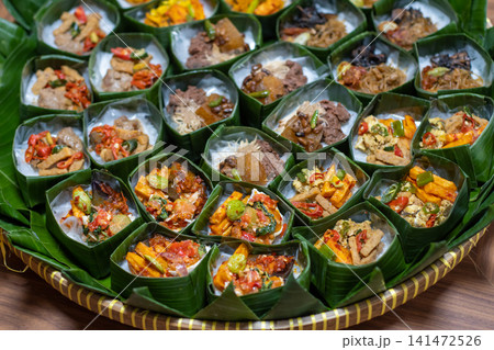 Traditional Indonesian Rice Served in Banana Leaf Takir with Assorted Toppings on Bamboo Tray, Homemade Catering Meals, Authentic Nusantara Cuisine, Eco Friendly Food Presentation Traditional Indonesian Rice Served in Banana Leaf Takir with Assorted Toppings on Bamboo Tray, Homemade Catering Meals, Authentic Nusantara Cuisine, Eco Friendly Food Presentation 141472526