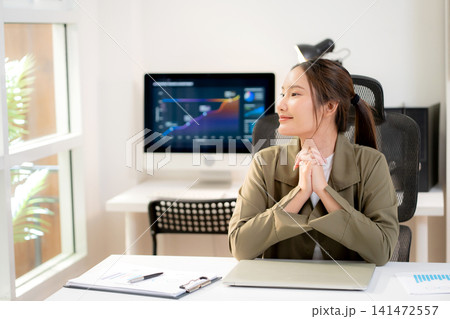 Asian young businesswoman sitting and working at modern office desk with laptop computer. Asian young businesswoman sitting and working at modern office desk with laptop computer. 141472557