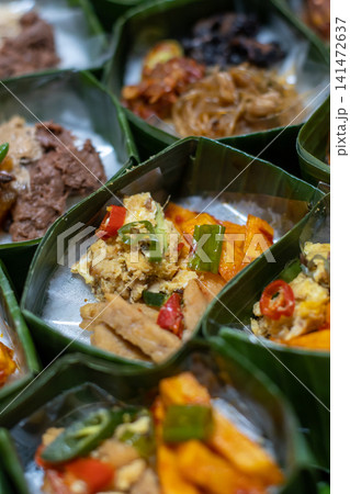 Traditional Indonesian Rice Meal in Banana Leaf Takir with Spicy Tofu, Tempeh, Egg and Sambal, Authentic Nusantara Cuisine, Eco Friendly Food Packaging and Homemade Catering Traditional Indonesian Rice Meal in Banana Leaf Takir with Spicy Tofu, Tempeh, Egg and Sambal, Authentic Nusantara Cuisine, Eco Friendly Food Packaging and Homemade Catering 141472637