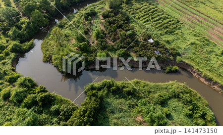 Aerial view of river flowing through abundance landscape in rural area of Chiang Rai province of Thailand. Aerial view of river flowing through abundance landscape in rural area of Chiang Rai province of Thailand. 141473150