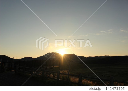 熊本県阿蘇市の草千里ヶ浜で撮影された朝日に輝く広大な大草原と池、噴煙を上げる阿蘇中岳の日の出風景 熊本県阿蘇市の草千里ヶ浜で撮影された朝日に輝く広大な大草原と池、噴煙を上げる阿蘇中岳の日の出風景 141473395
