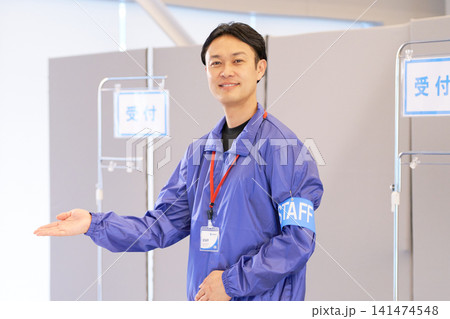 案内板の横で笑顔を見せる男性受付スタッフ 案内板の横で笑顔を見せる男性受付スタッフ 141474548