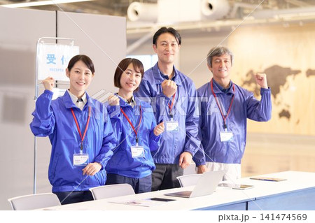 受付の前で笑顔を見せるイベント運営スタッフ 141474569