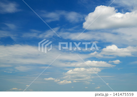 cumulus clouds and white streaks in blue sky cumulus clouds and white streaks in blue sky 141475559