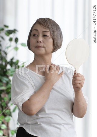 手鏡を持つシニア女性 141477126