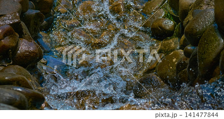 Rapid stream with fresh water among boulders and stones Rapid stream with fresh water among boulders and stones 141477844