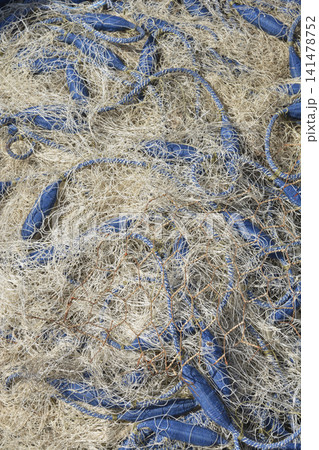 Tangled commercial fishing net with blue floats full frame. Tangled commercial fishing net with blue floats full frame. 141478752