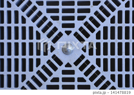 Grey plastic drainage grate with geometric grid pattern close up Grey plastic drainage grate with geometric grid pattern close up 141478819