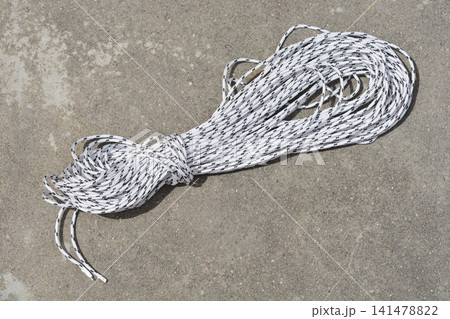 Coiled white and black nylon rope on concrete floor Coiled white and black nylon rope on concrete floor 141478822
