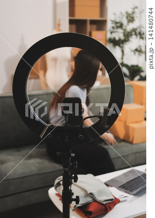 Woman recording live stream preparing packages for online selling 141480744
