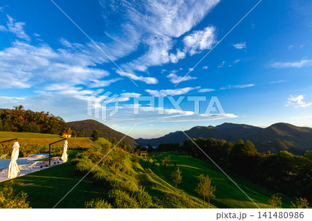 スイス・ルガーノ近郊の丘から望む緑の山と湖の夕景 スイス・ルガーノ近郊の丘から望む緑の山と湖の夕景 141480986