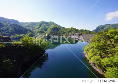 晴天のダム湖に映える美しいコバルトブルーの水面と青空 晴天のダム湖に映える美しいコバルトブルーの水面と青空 141481290