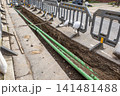 Utility trench with green pipes along street excavation 141481488