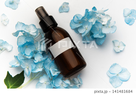 Cosmetic spray bottle with blue hydrangea petals Cosmetic spray bottle with blue hydrangea petals 141481684
