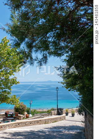 Scenic stone path viewpoint overlooking the turquoise sea in Afytos, Kassandra, Halkidiki, Greece Scenic stone path viewpoint overlooking the turquoise sea in Afytos, Kassandra, Halkidiki, Greece 141481858
