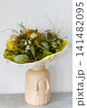 Bouquet of dried flowers in an original ceramic face vase 141482095